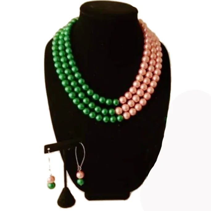 AKA pink and green pearl earring, bracelet, and necklace set inspired by Alpha Kappa Alpha displayed on black jewelry stand.