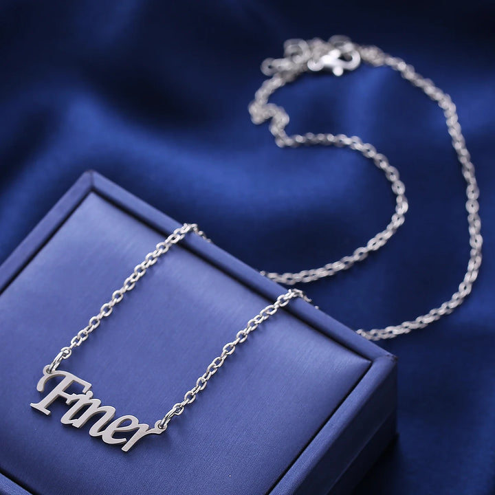 Stainless steel Zeta Phi Beta Finer necklace on blue fabric, essential sorority paraphernalia for black Greek lettered organization members.