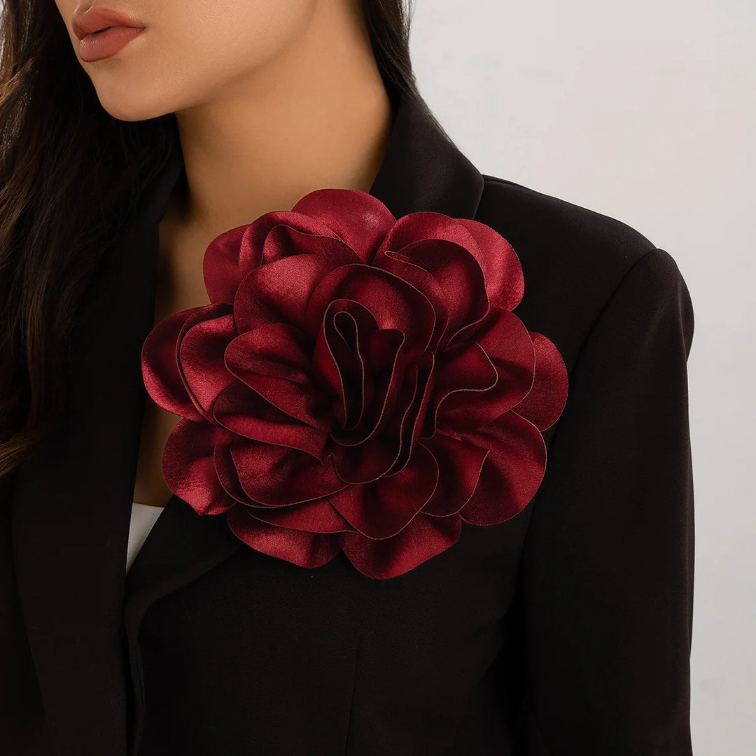 Woman wearing sorority flower brooch in crimson on black jacket, perfect sorority paraphernalia for black greek lettered organizations, women's clothing.